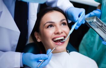 A Perfect Smile! A dentist examining his beautiful patient in the dental office.