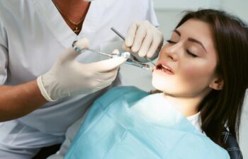 Dentist examining a patient's teeth in modern dentistry office.