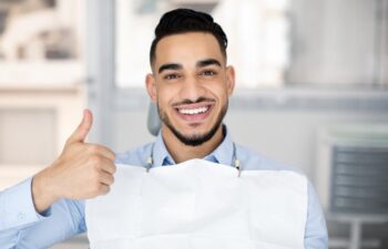 Portrait Of Happy Middle Eastern Guy Sitting In Dentist Chair And Showing Thumb Up