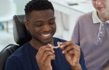 African American man wearing clear braces in order to get rid of malocclusion