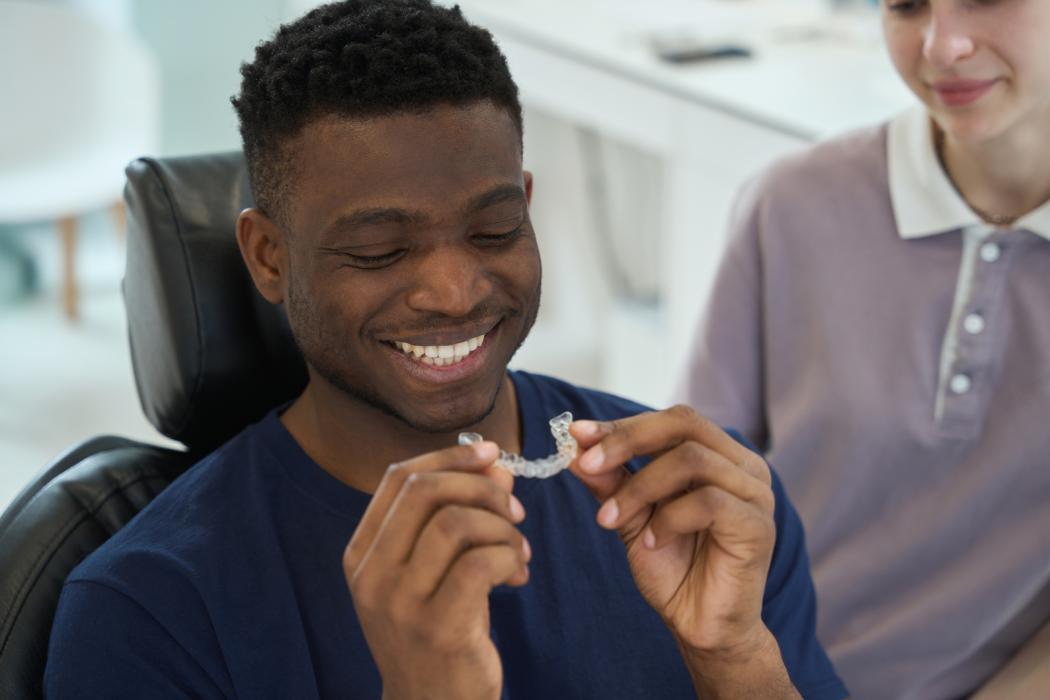 African American man wearing clear braces in order to get rid of malocclusion