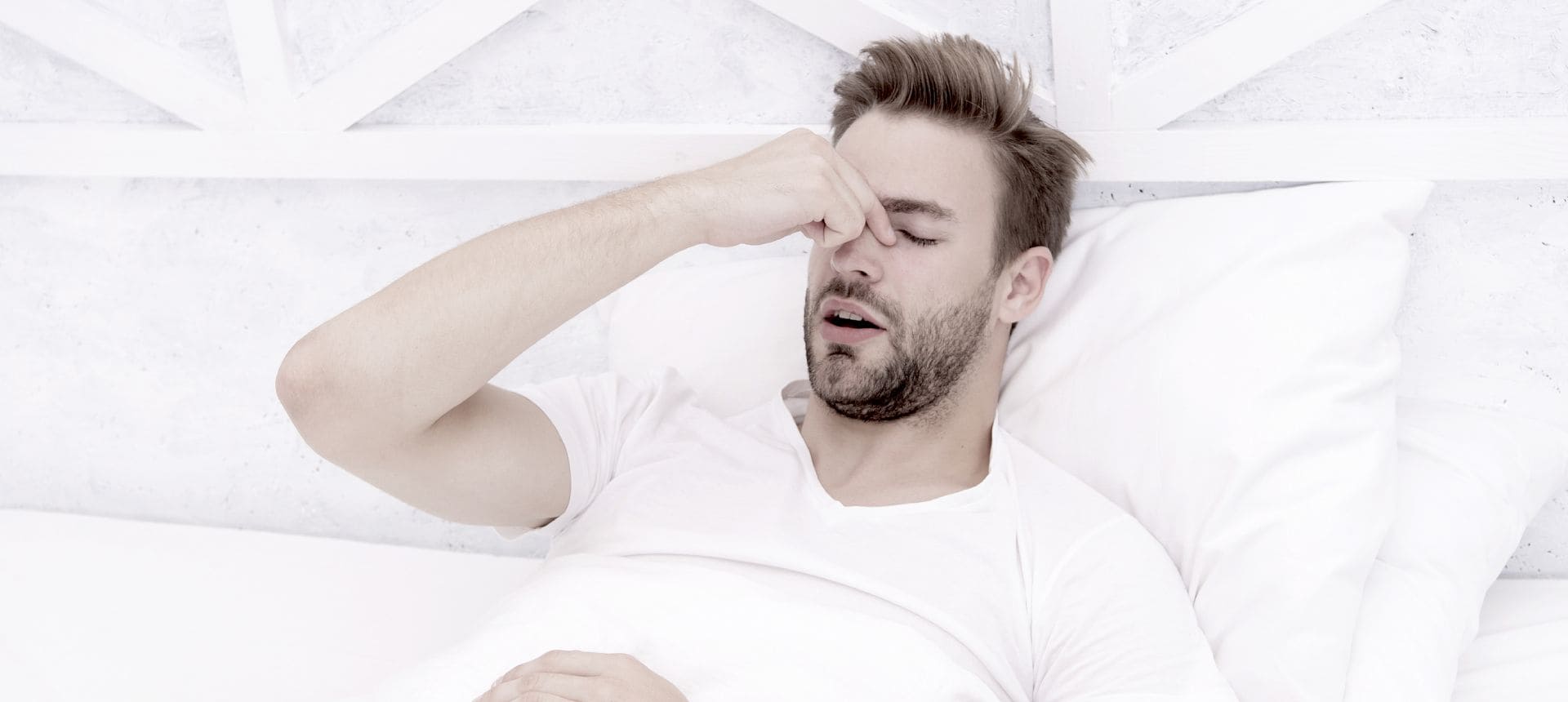 Man in bed with a headache