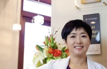 Dr. Park in front of Top Dentist Sign